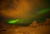 Wenn das Polarlicht stark genug ist, scheint es sogar durch eine Wolkendecke hindurch, die von unten von den Lampen einer Stadt angestrahlt werden. Hetta, Finnland