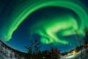 Das gewaltige Polarlicht über Äkäslompolo im Norden Finnlands nimmt fast den ganzen Himmel ein. Um es zu fotografieren, musste ich zu meinem stärksten Fischauge-Weitwinkel greifen. Deshalb biegt sich der Horizont am unteren Bildrand so stark durch. Nur so konnte ich fast den ganzen Himmel im Bild erfassen.